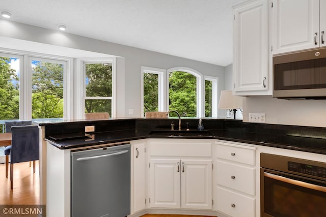 13840 Edenwood Way, Apple Valley, MN 55124 - kitchen with appliances with stainless steel finishes, white cabinets, and a peninsula