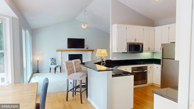 13840 Edenwood Way, Apple Valley, MN 55124 - kitchen featuring stainless steel appliances, lofted ceiling, a peninsula, a ceiling fan, and dark countertops
