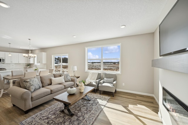 757 Greywood Blvd SW, Delano, MN 55328 - living area featuring light wood-style floors, a chandelier, recessed lighting, and a textured ceiling