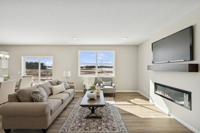 757 Greywood Blvd SW, Delano, MN 55328 - living room featuring wood finished floors, a glass covered fireplace, recessed lighting, a textured ceiling, and a chandelier
