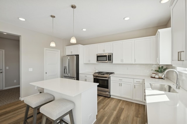 757 Greywood Blvd SW, Delano, MN 55328 - kitchen featuring appliances with stainless steel finishes, wood finished floors, backsplash, a center island, and a kitchen breakfast bar