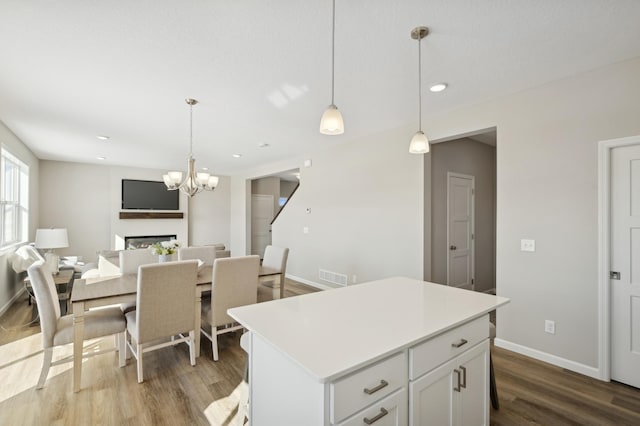 757 Greywood Blvd SW, Delano, MN 55328 - kitchen with wood finished floors, a kitchen island, light countertops, a chandelier, and white cabinets