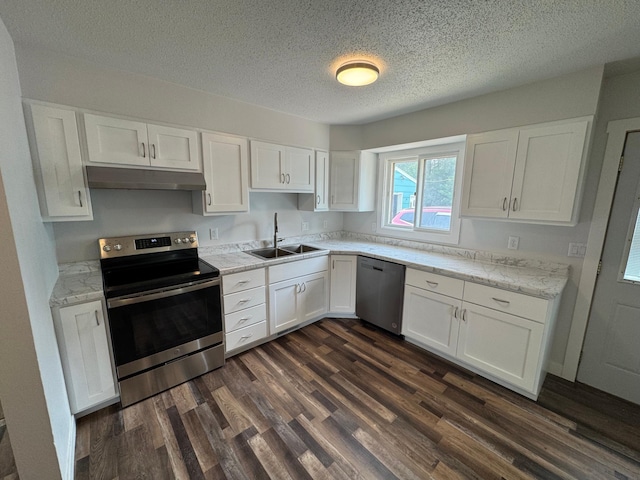406 22nd St S, Fargo, ND 58103 - kitchen with stainless steel appliances, under cabinet range hood, white cabinetry, dark wood finished floors, and a textured ceiling