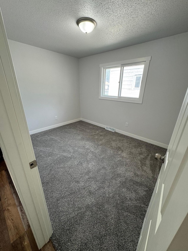 406 22nd St S, Fargo, ND 58103 - spare room featuring a textured ceiling and dark colored carpet