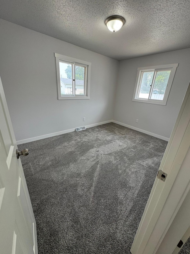 406 22nd St S, Fargo, ND 58103 - empty room featuring a textured ceiling and dark colored carpet