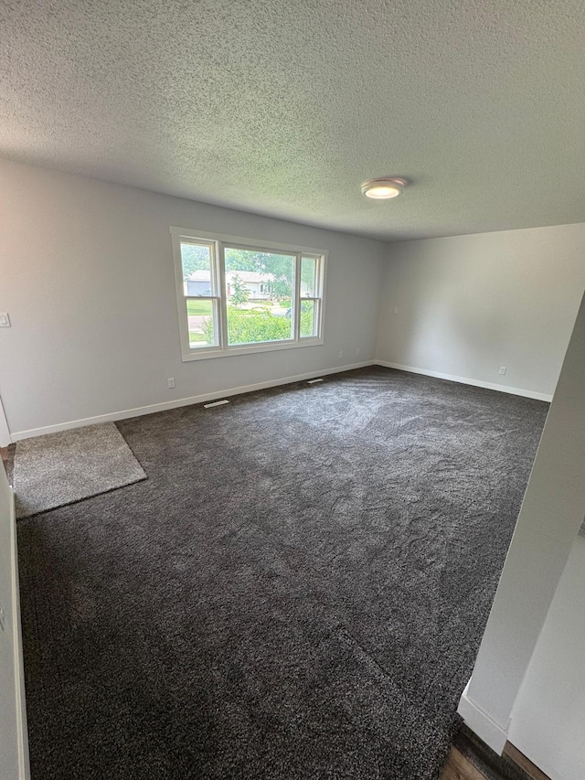 406 22nd St S, Fargo, ND 58103 - spare room featuring dark colored carpet and a textured ceiling