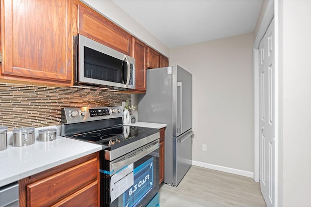 6494 Bonner Ct, Inver Grove Heights, MN 55076 - kitchen with appliances with stainless steel finishes, tasteful backsplash, light wood-type flooring, brown cabinetry, and light stone counters