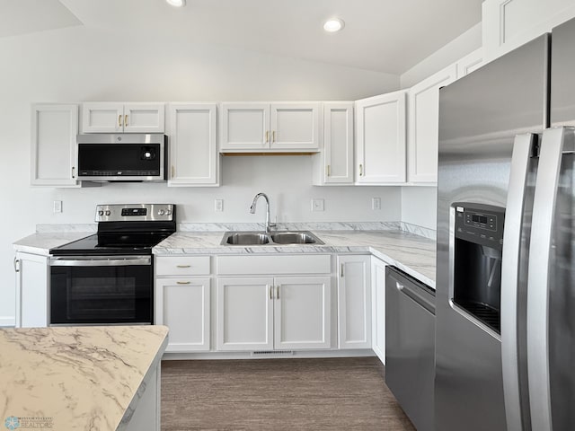 4832 51st Ave S, Fargo, ND 58104 - kitchen featuring appliances with stainless steel finishes, vaulted ceiling, white cabinets, light stone counters, and recessed lighting