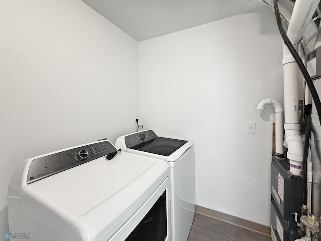 4832 51st Ave S, Fargo, ND 58104 - laundry area featuring independent washer and dryer, wood finished floors, and heating unit
