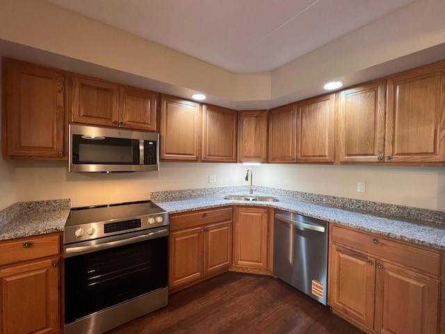 2485 Londin Ln E Unit 418, Maplewood, MN 55119 - kitchen featuring stainless steel appliances, dark wood-type flooring, light stone counters, and brown cabinetry