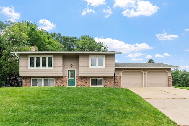 540 4th St E, Wanamingo, MN 55983 - bi-level home featuring concrete driveway, a front lawn, brick siding, a garage, and a chimney
