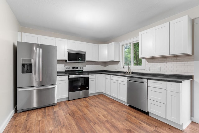 540 4th St E, Wanamingo, MN 55983 - kitchen featuring appliances with stainless steel finishes, dark countertops, and decorative backsplash