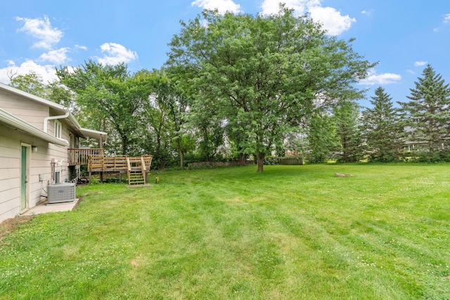540 4th St E, Wanamingo, MN 55983 - view of grassy yard featuring a wooden deck and view of wooded area