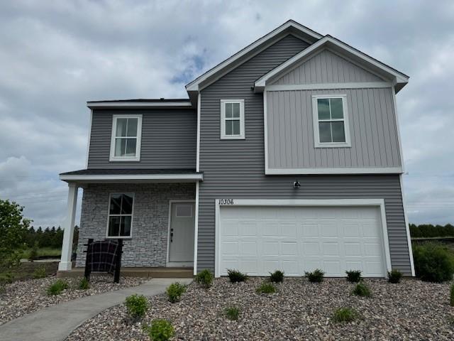 4943 Airlake Dr, Woodbury, MN 55129 - view of front facade featuring a garage, stone siding, and covered porch