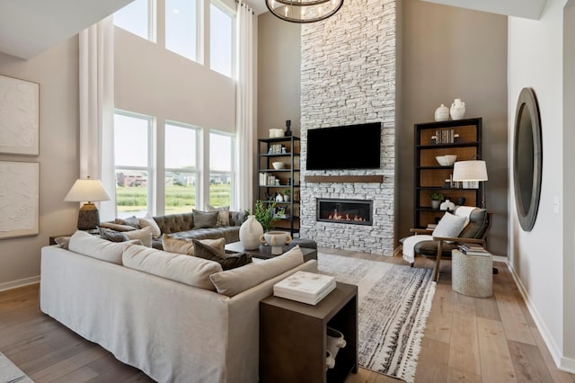 14540 106th Pl N, Maple Grove, MN 55369 - living area featuring a high ceiling, light wood-style floors, healthy amount of natural light, and a stone fireplace