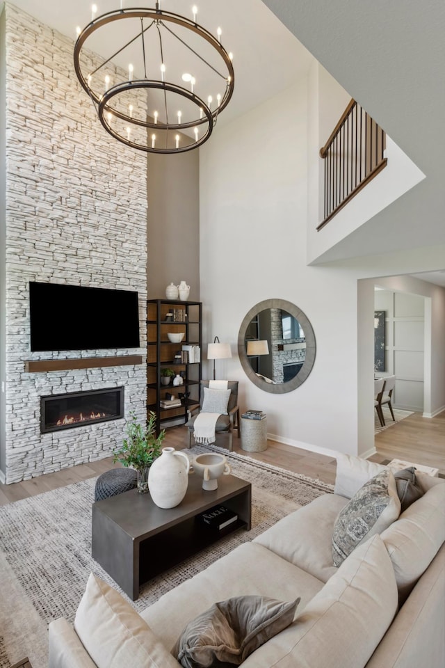 14540 106th Pl N, Maple Grove, MN 55369 - living area featuring wood finished floors, a towering ceiling, a chandelier, and a stone fireplace