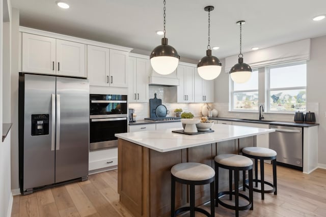 14540 106th Pl N, Maple Grove, MN 55369 - kitchen featuring appliances with stainless steel finishes, light wood-type flooring, tasteful backsplash, a center island, and recessed lighting