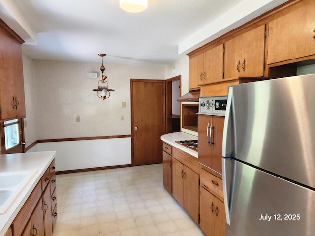 5043 Overlook Cir, Bloomington, MN 55437 - kitchen featuring freestanding refrigerator, light flooring, light countertops, brown cabinets, and hanging light fixtures