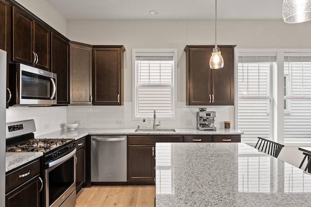 8120 Arrowwood Ln N, Maple Grove, MN 55369 - kitchen with stainless steel appliances, dark brown cabinets, light stone counters, and decorative backsplash