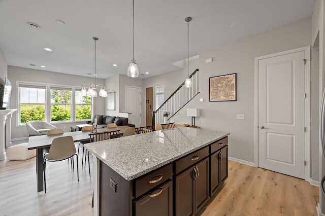 8120 Arrowwood Ln N, Maple Grove, MN 55369 - kitchen with light wood-type flooring, dark brown cabinetry, recessed lighting, open floor plan, and a center island