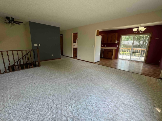18627 148th St NW, Big Lake Twp, MN 55330 - unfurnished living room featuring a chandelier, carpet flooring, a textured ceiling, and ceiling fan