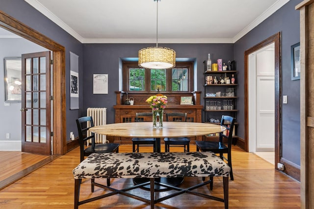 2612 52nd St, Minneapolis, MN 55410 - dining space featuring radiator, light wood finished floors, and ornamental molding