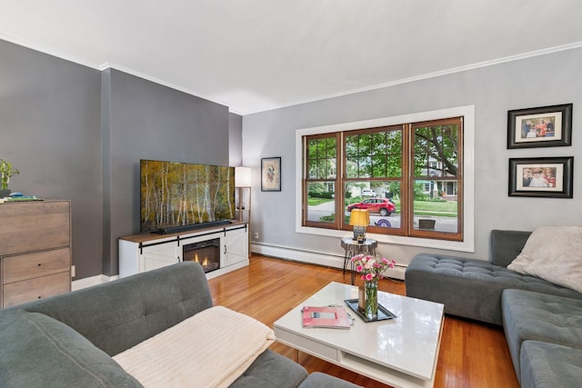 2612 52nd St, Minneapolis, MN 55410 - living room featuring light wood finished floors, crown molding, a baseboard heating unit, and a warm lit fireplace