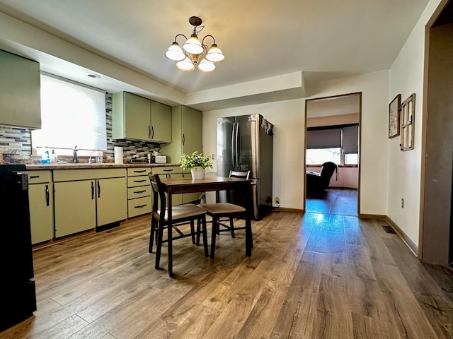 2716 Canterbury Dr, Bigelow, MN 56117 - kitchen with freestanding refrigerator, green cabinets, light wood-style floors, a chandelier, and tasteful backsplash