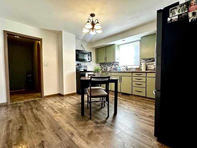 2716 Canterbury Dr, Bigelow, MN 56117 - kitchen featuring black appliances, wood finished floors, a chandelier, backsplash, and green cabinets