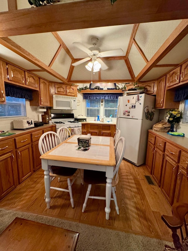 15827 Wilderness Trl Unit 127, Crosslake, MN 56442 - kitchen featuring white appliances, light wood-style floors, brown cabinets, ceiling fan, and tile counters