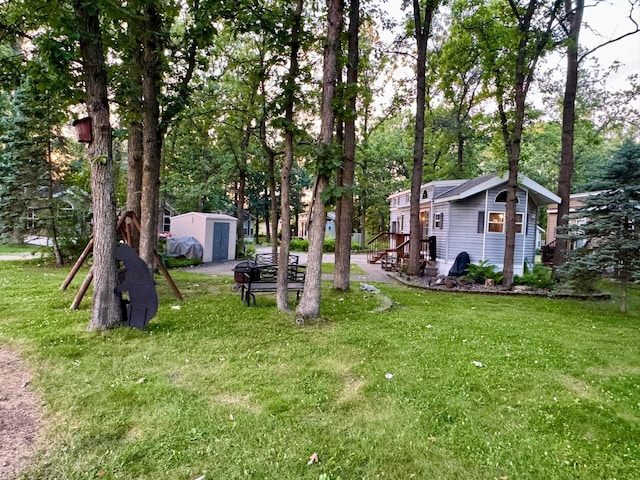 15827 Wilderness Trl Unit 127, Crosslake, MN 56442 - view of green lawn featuring a storage unit and view of wooded area