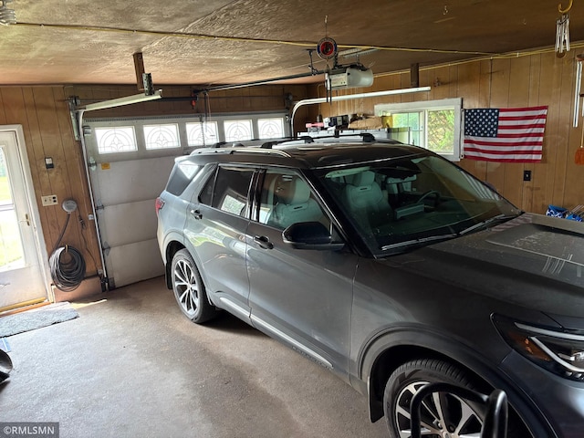 W5168 Lake Rd, Warner Twp, WI 54437 - garage with wooden walls and a garage door opener
