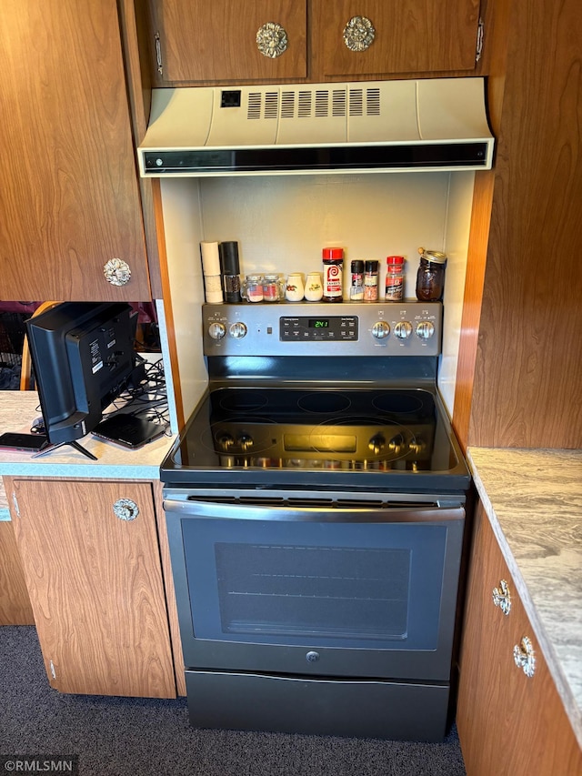 W5168 Lake Rd, Warner Twp, WI 54437 - kitchen featuring stainless steel electric range, extractor fan, light countertops, and brown cabinets