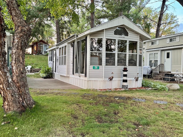 15827 Wilderness Trl Unit 28, Crosslake, MN 56442 - view of side of home featuring a lawn and a sunroom