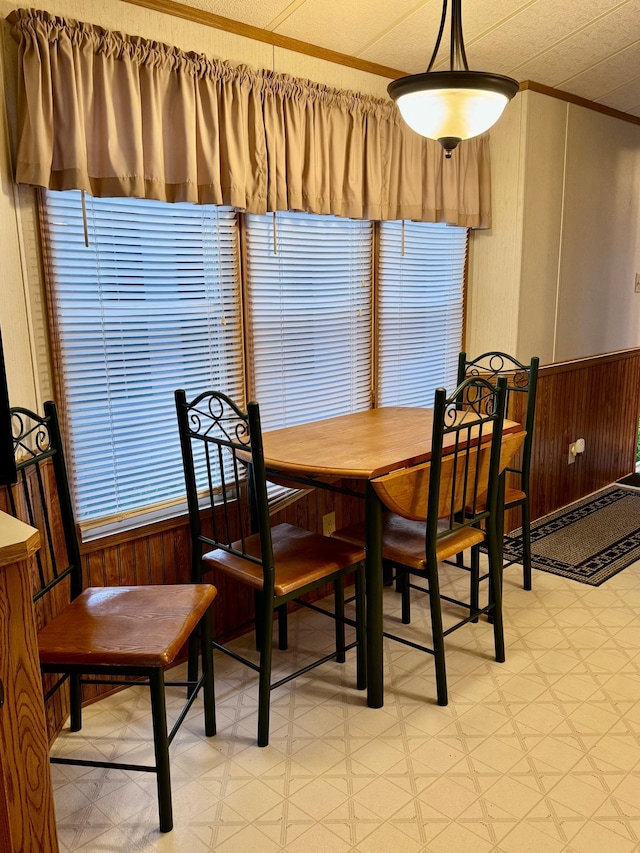 15827 Wilderness Trl Unit 28, Crosslake, MN 56442 - dining area featuring light floors, wood walls, ornamental molding, and wainscoting