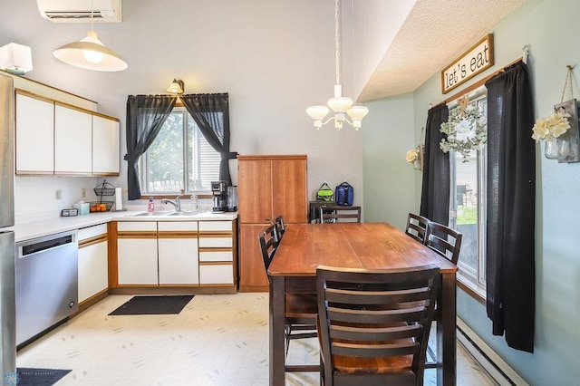 1426 11th St W, West Fargo, ND 58078 - kitchen with dishwasher, a chandelier, a wall mounted AC, white cabinets, and pendant lighting