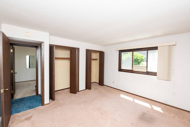 1290 Polk Pl, Columbia Heights, MN 55421 - unfurnished bedroom with light carpet, a textured ceiling, and multiple closets