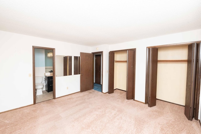 1290 Polk Pl, Columbia Heights, MN 55421 - unfurnished bedroom featuring light colored carpet, multiple closets, and ensuite bath