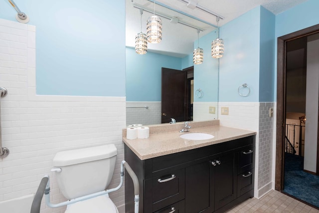 1290 Polk Pl, Columbia Heights, MN 55421 - bathroom featuring tile walls, vanity, wainscoting, and tile patterned flooring