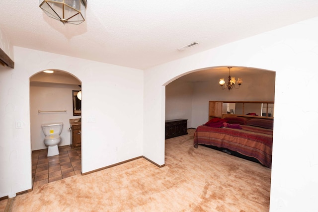 1290 Polk Pl, Columbia Heights, MN 55421 - bedroom with arched walkways, light colored carpet, a chandelier, and ensuite bath