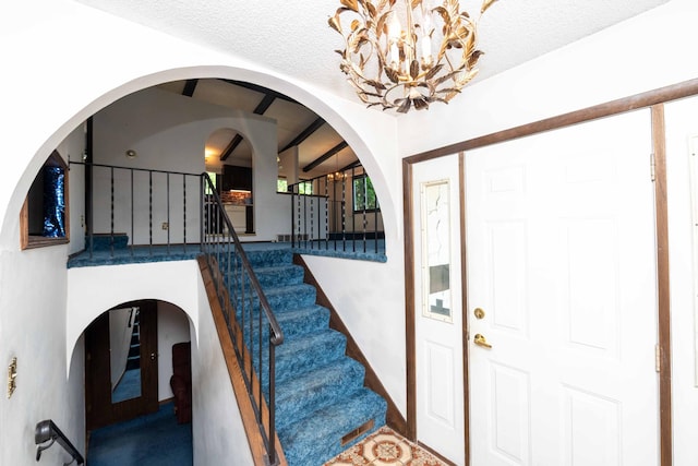 1290 Polk Pl, Columbia Heights, MN 55421 - entryway with stairway, a chandelier, a textured ceiling, and arched walkways
