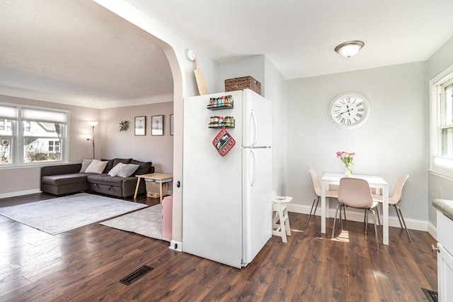 1034 Carroll Ave, Saint Paul, MN 55104 - kitchen featuring freestanding refrigerator, wood finished floors, arched walkways, and plenty of natural light