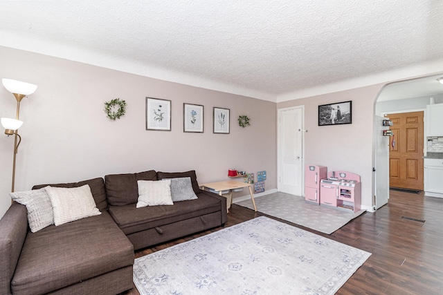 1034 Carroll Ave, Saint Paul, MN 55104 - living area with arched walkways, a textured ceiling, and dark wood-style floors