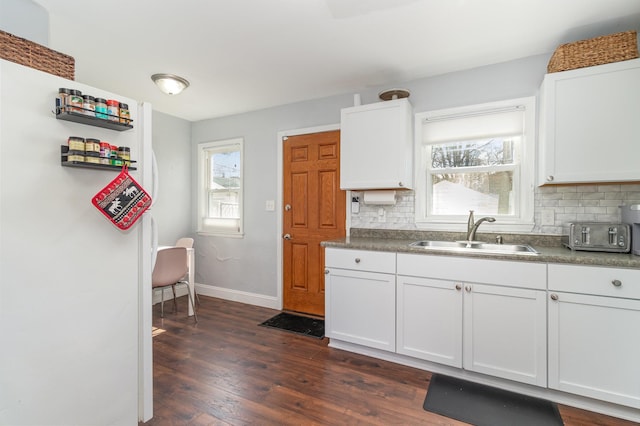 1034 Carroll Ave, Saint Paul, MN 55104 - kitchen featuring freestanding refrigerator, backsplash, dark wood-style flooring, and white cabinets