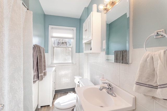 1034 Carroll Ave, Saint Paul, MN 55104 - bathroom with tile walls, a wainscoted wall, vanity, and wood finished floors