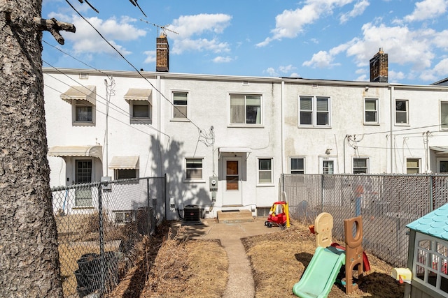 1034 Carroll Ave, Saint Paul, MN 55104 - back of house with a chimney, entry steps, stucco siding, and a playground