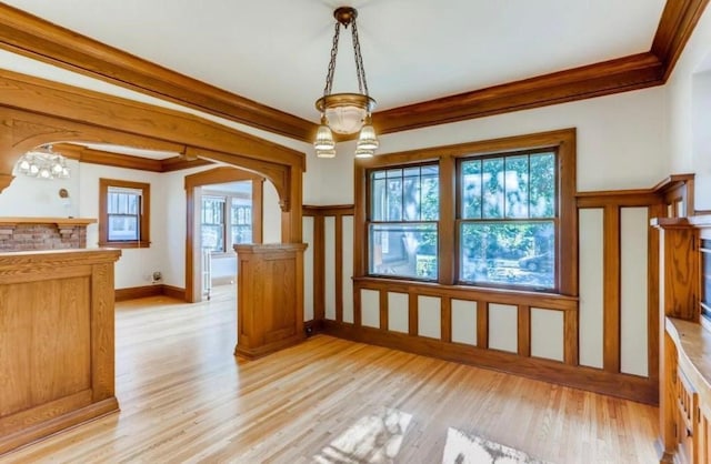 4105 Columbus Ave, Minneapolis, MN 55407 - unfurnished dining area featuring ornamental molding, light wood-style floors, arched walkways, and a chandelier