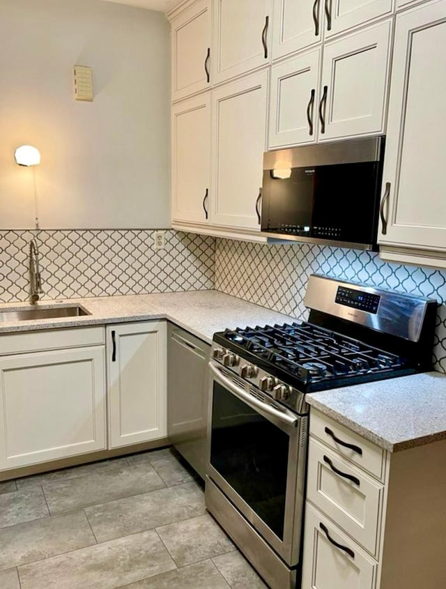 4105 Columbus Ave, Minneapolis, MN 55407 - kitchen with stainless steel appliances, tasteful backsplash, and light stone countertops