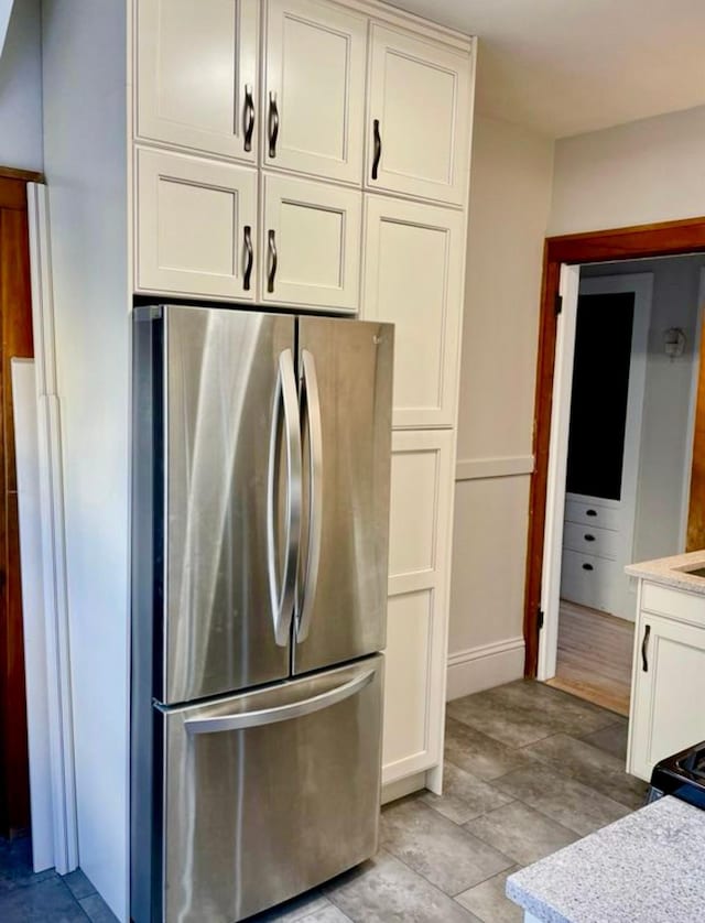 4105 Columbus Ave, Minneapolis, MN 55407 - kitchen featuring freestanding refrigerator, light countertops, and white cabinets