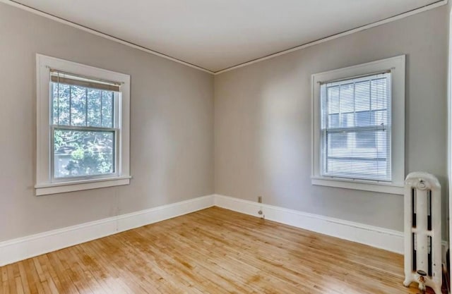 4105 Columbus Ave, Minneapolis, MN 55407 - unfurnished room with wood finished floors, crown molding, and radiator